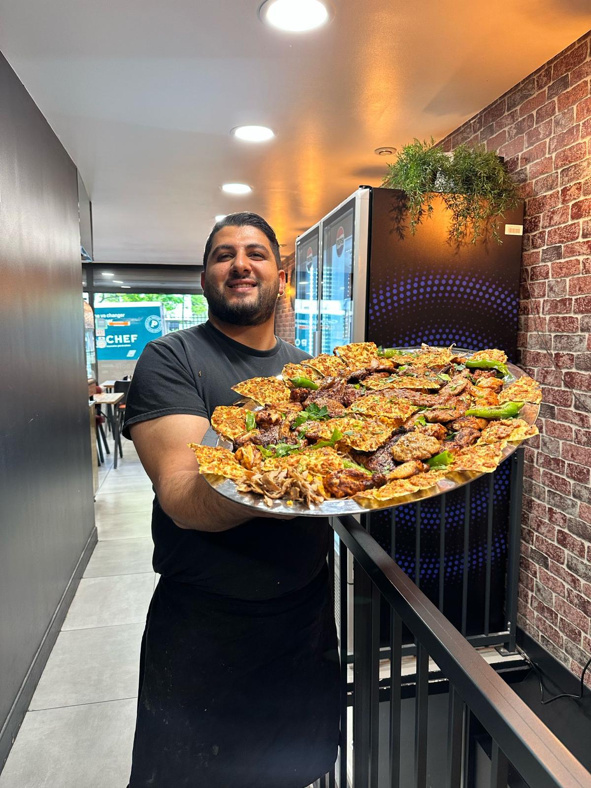 Le chef de Varto Grill présentant un plateau de grillades